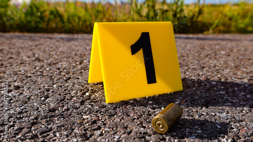 Fotografie Yellow forensic evidence marker with the number one highlighting a spent bullet