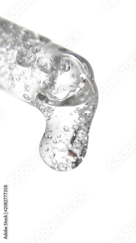 Vertical cosmetic serum fluid gel with bubbles from dropper, pipette over white
