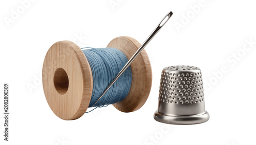 Wooden spool of blue thread with needle and thimble