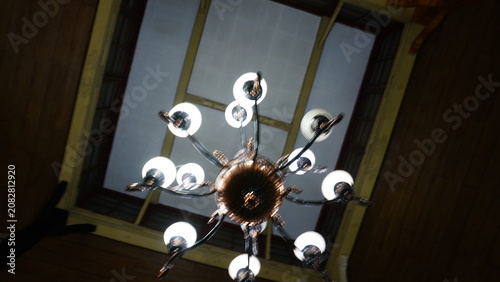 A close-up of a hanging pendant lamp captured in low-light conditions with a partially blurred object, creating a soft bokeh effect and a warm, moody atmosphere. Ideal for themes of interior design, a
