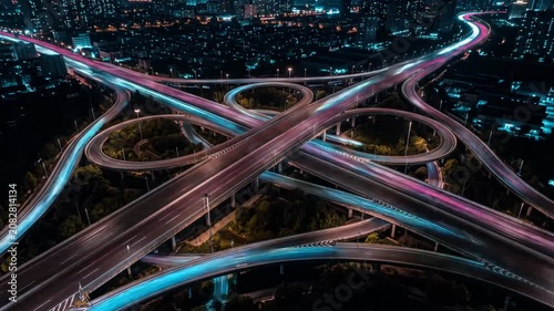 Multi-colored light trails on a complex night interchange.