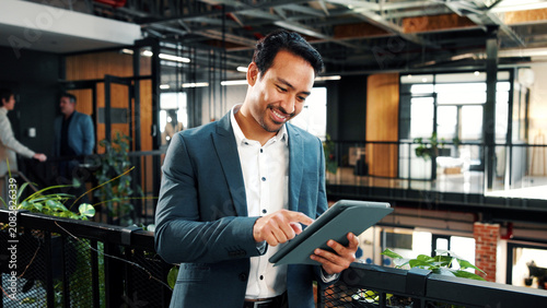 Man  scroll and tablet in office with sustainable business  research or happy with ESG compliance. Coworking  person and typing in eco friendly company with tech  smile or audit for carbon footprint.