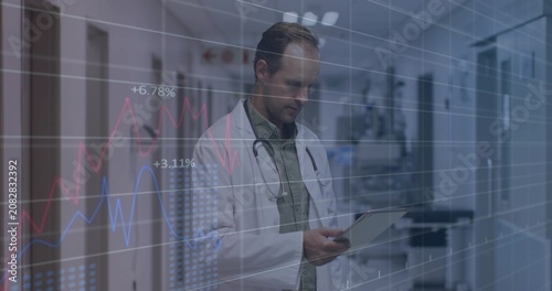 Overlay rising doctor in labcoat with stethoscope reviewing data on tablet smiling in corridor