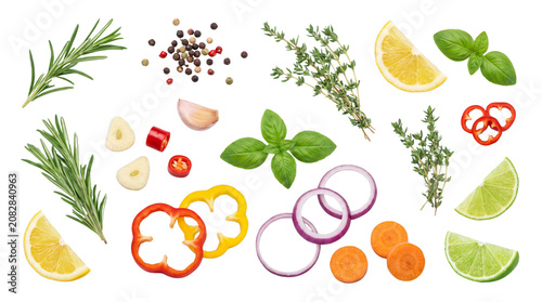 Fresh vegetable and herb assortment with lemon and onion slices for healthy cooking.