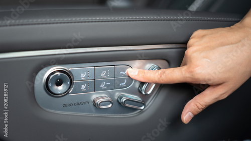 фотографія Adjusting the premium leather car passenger seat using the automatic electronic adjustment switch panel