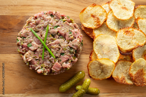 Fotografi A top down view of steak tartare and homemade potato chips.