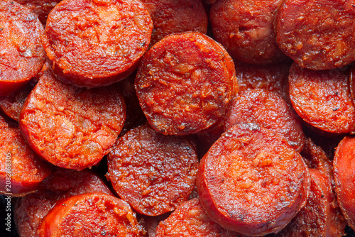 Spicy traditional sliced fried Spanish chorizo sausage background backdrop. Traditional Spanish food concept.