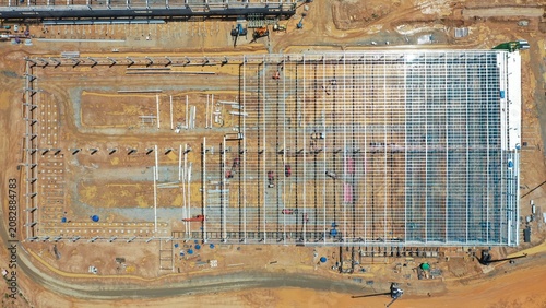 фотографія Industrial Construction Site: An aerial view showcases the vast scale of a modern industrial construction site, with steel framework and foundation being laid for a large structure