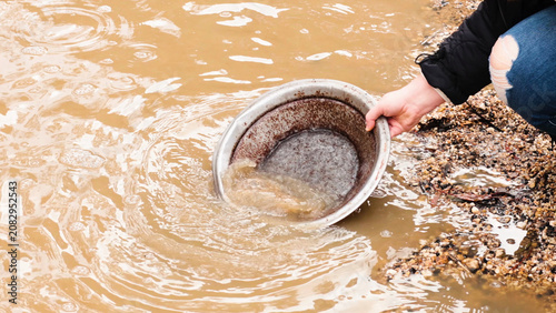 Foto Person Panning for Gold in Muddy Water at Ballarat Heritage Site