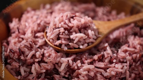 Cooked Riceberry Rice in a Wooden Bowl with Wooden Spoon on a Wooden Table