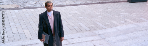 Bild auf Leinwand Stylish young man stands confidently in the city, ready for an exciting day of l