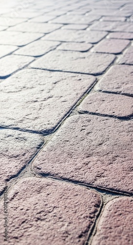 Close-up view of rough textured natural stone patio pavers installed in a geometric pattern for durable outdoor backyard flooring, pattern, paving, rugged