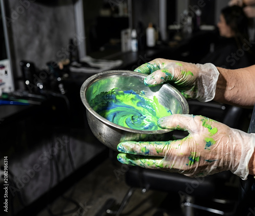 Hair Colorist Stained Silicone Gloves Holding Silver Tint Bowl with Neon Dye
