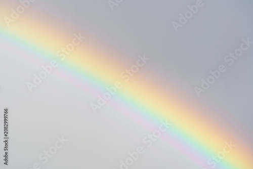 Natural rainbow across soft gray sky with pastel colors
