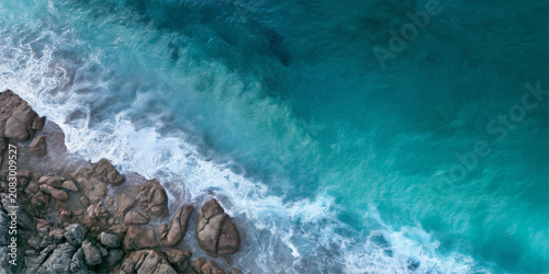 фотографія Powerful Ocean Waves Crashing on Rocky Beach Coast with Sea Foam, Blue Water, St