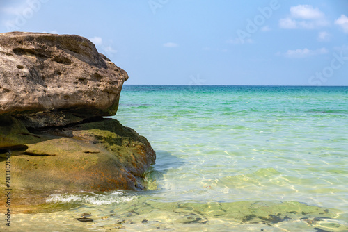 Crystal Clear Turquoise Sea Water with Rocky Coastal Boulder on Sunny Tropical Beach