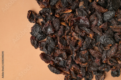 Organic dried fruit background showing dark wrinkled plums with realistic texture. Organic produce highlights clean nutrition, natural ingredients, wholesome food marketing and healthy product 