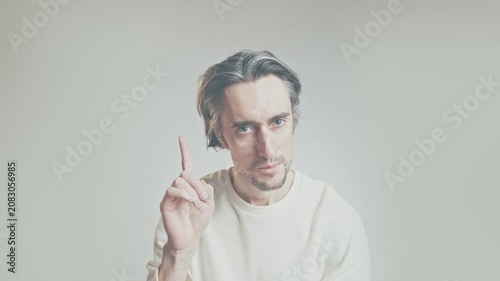 Middle-aged man raising index finger, close up portrait on neutral background in light sweater, attention and instruction gesture, communication concept