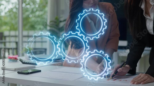Business team reviewing reports with virtual gears overlay, representing workflow automation, process improvement, collaboration and business strategy.