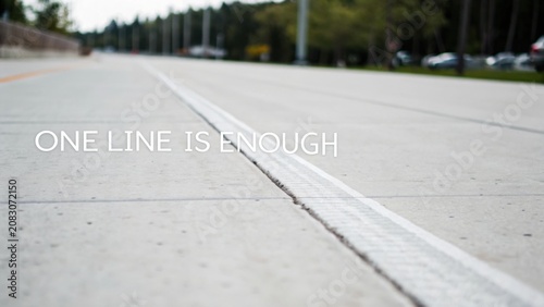 Concrete pathway with white line, urban setting, trees in background, minimalistic design, modern transportation route