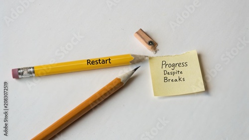 Creative Workspace with Pencil, Sharpener, Sticky Note with Motivational Message about Progress and Restart Inspiration