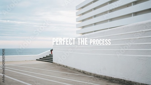 Minimalist architectural scene with a coastal view and motivational text on a clean white wall surrounded by calm colors