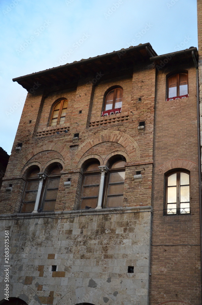 Obraz premium San Gimignano, Italy 03.04.2020: Town Hall (also known as the Palazzo del Popolo or Palazzo Nuovo del Podestà) and the Torre Grossa in San Gimignano