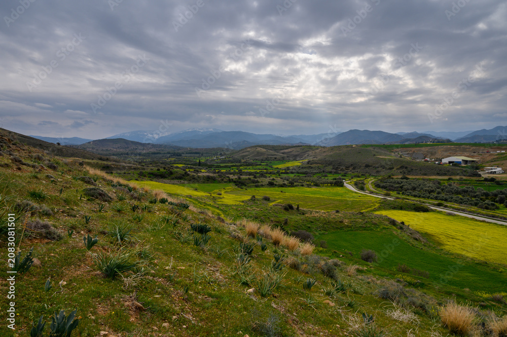 Obraz premium Expansive green hills and dramatic sky showcase nature's beauty in a serene