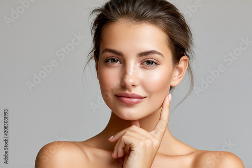 Young woman smiles while posing for a studio shot