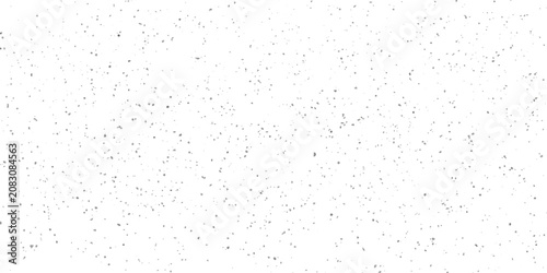 Foto A scattering of small, dark particles dispersed across a stark white background, resembling dust or fine confetti in a minimalist composition