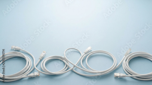 Network ethernet cables arranged on a clean pastel blue background