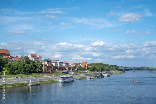 Canvastavla Panoramic view of the historic medieval old town of Torun featuring its red brick gothic architecture along the Vistula River under a sunny blue sky
