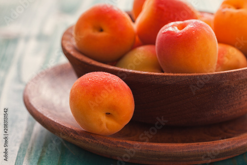Fresh ripe apricots on the blue wooden background