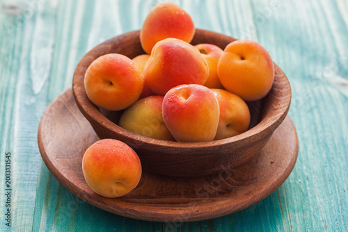 Fresh ripe apricots on the blue wooden background