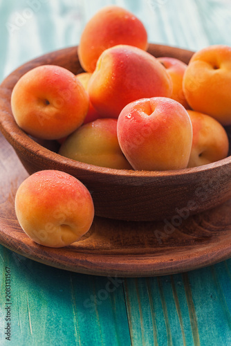 Fresh ripe apricots on the blue wooden background