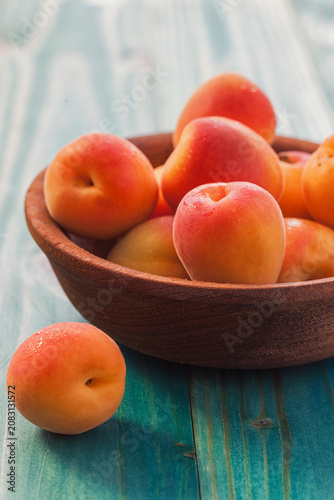 Fresh ripe apricots on the blue wooden background
