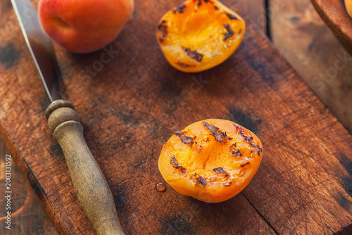Freshly grilled apricots with honey on the wooden background