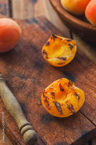 Freshly grilled apricots with honey on the wooden background