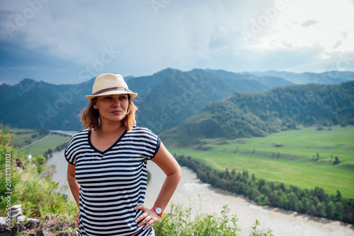 Принти на полотні Female traveler standing on a mountain viewpoint above a winding river valley, e