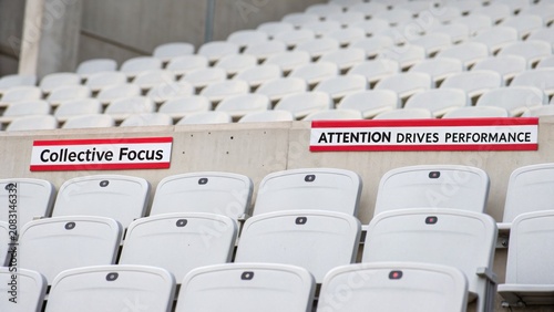 Motivational Signs in Empty Stadium Seats Symbolizing Team Spirit and Commitment to Excellence in Sports Performance