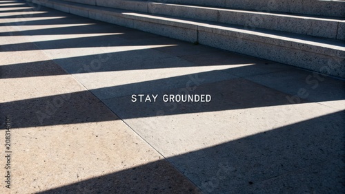 Shadows and Light on Architectural Steps with Inspirational Message Stay Grounded in Urban Environment