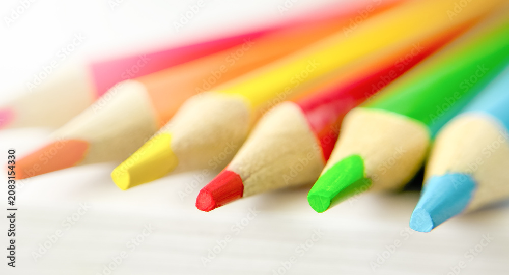Fototapeta premium Colorful pencils on white sheet of paper. MACRO PENCILS