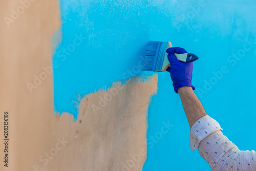 Paints the pool with blue paint. Selective focus.