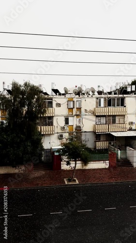 Cold hail falling on urban apartment building street