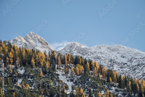 Snow-Covered Ruitlspitze Mountain Peak above a Vibrant Autumn Forest with Golden Larches in the Lechtal Alps, Scenic Alpine Landscape in Tyrol Austria