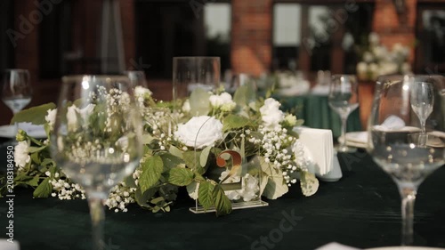 Wedding reception table adorned with a floral centerpiece, glassware, and elegant table settings, creating a beautiful atmosphere for guests