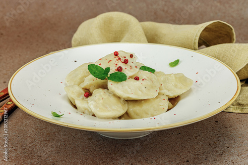 Traditional Ukrainian vareniki or pierogi with mint leaves and spices served on a ceramic plate