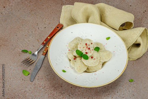 Traditional Ukrainian vareniki or pierogi with mint leaves and spices served on a ceramic plate