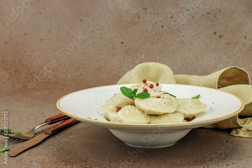 Traditional Ukrainian vareniki or pierogi with mint leaves and spices served on a ceramic plate