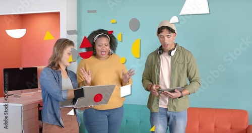 Presenter tapping laptop causing shapes layering while marketing team confirming details on tablet